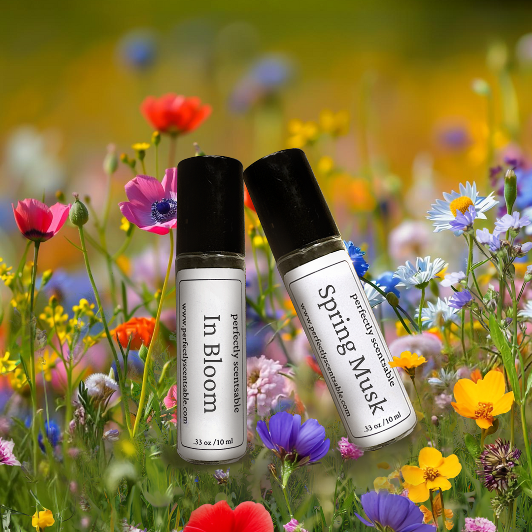 Two perfume bottles labeled In Bloom and Spring Musk set against a colorful wildflowers.