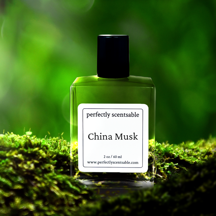 Perfectly Scentsable China Musk perfume oil, 2 oz/60 ml square bottle on lush moss against a bright green backdrop.