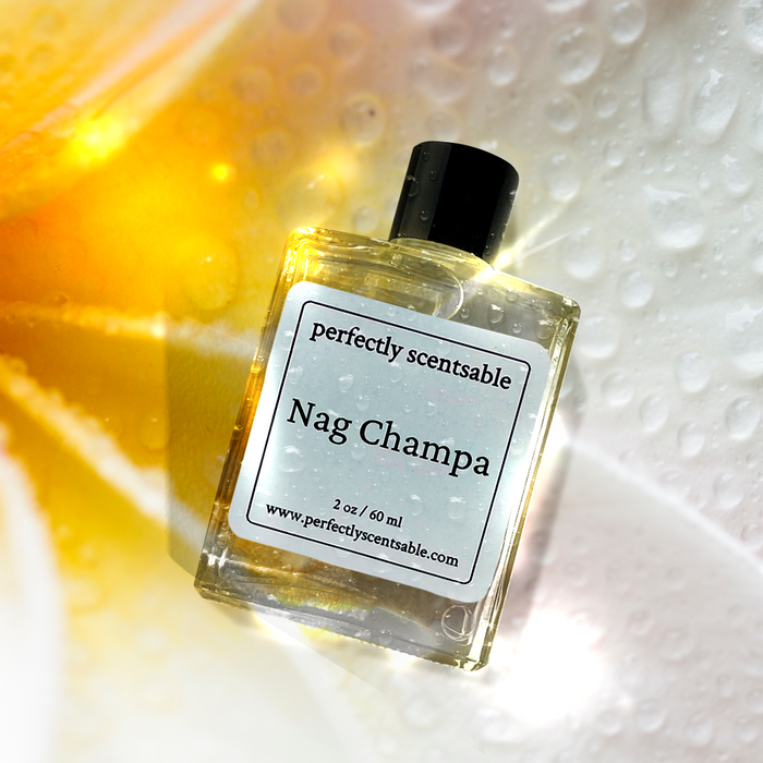 Perfectly Scentsable Nag Champa perfume oil, 2 oz/60 ml bottle with black cap and dewy glass, angled over a glowing plumeria petal background.