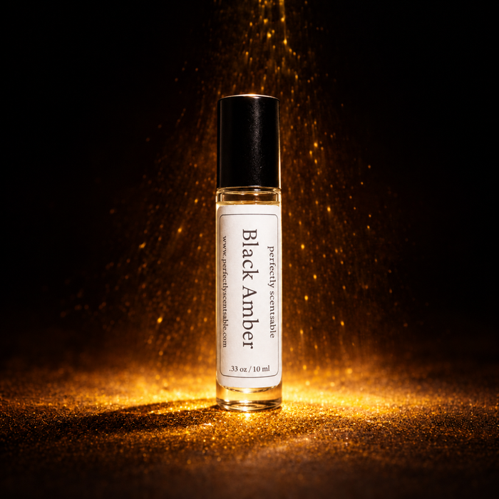 Black Amber roll-on perfume bottle standing against a dark background, illuminated by warm golden light with sparkling amber particles falling around it and glowing reflections on the surface.