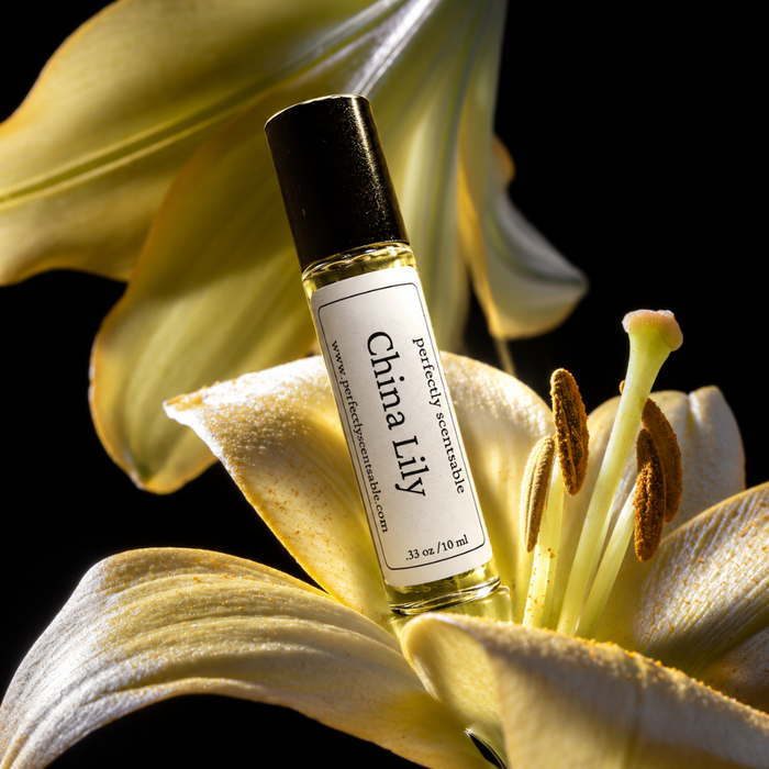 China Lily roll-on perfume bottle resting among large pale yellow lily petals, with prominent stamens and dramatic lighting against a dark background.
