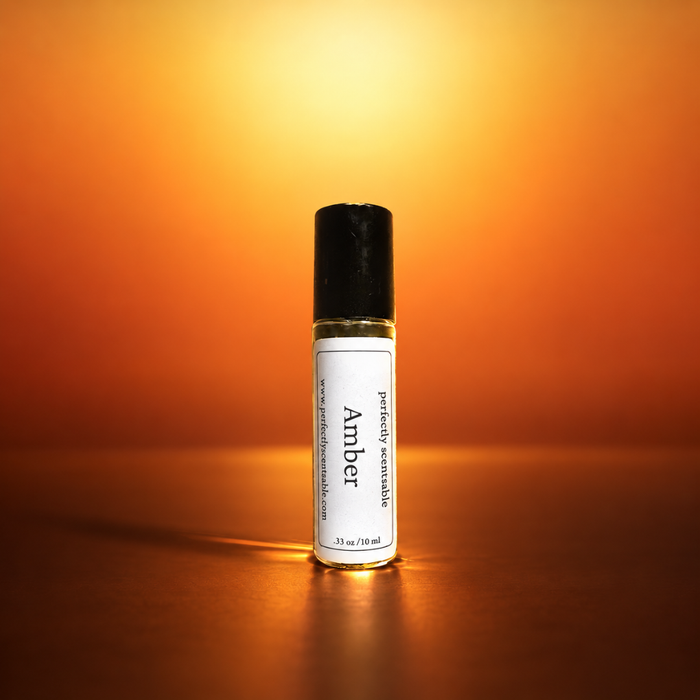 Amber roll-on perfume bottle centered against a warm glowing orange background, illuminated by soft golden light that creates a rich, elegant atmosphere and subtle reflections on the surface.