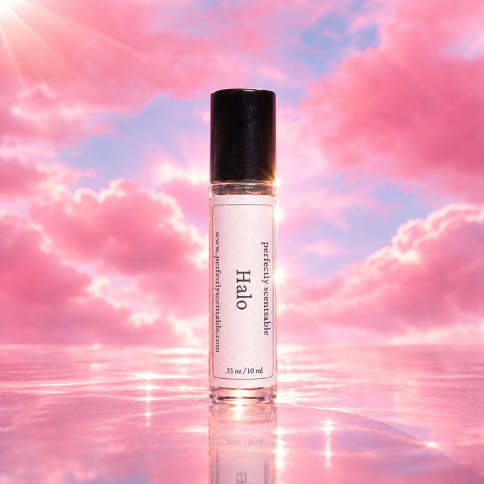 Halo roll-on perfume bottle centered against a dreamy pink and lavender cloud background, with soft glowing light and a reflective pink surface creating an airy, ethereal look.