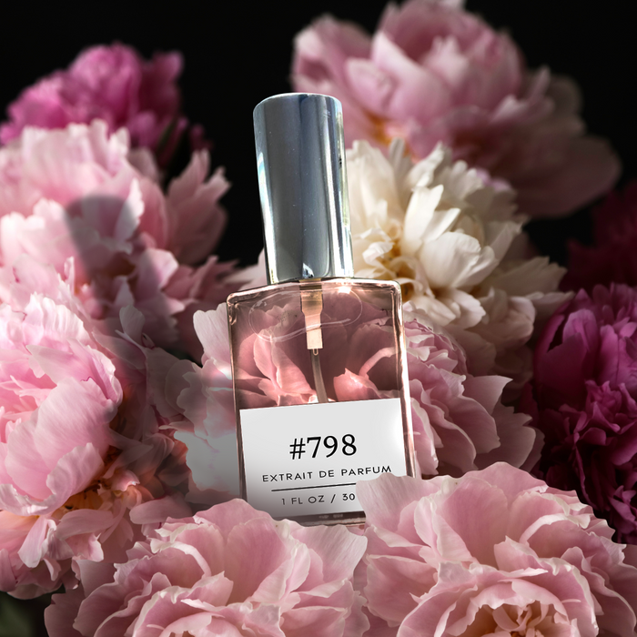 Formula #798 Extrait de Parfum bottle (1 fl oz / 30 ml) with a silver cap, nestled among lush pink and white peony blooms on a dark background.