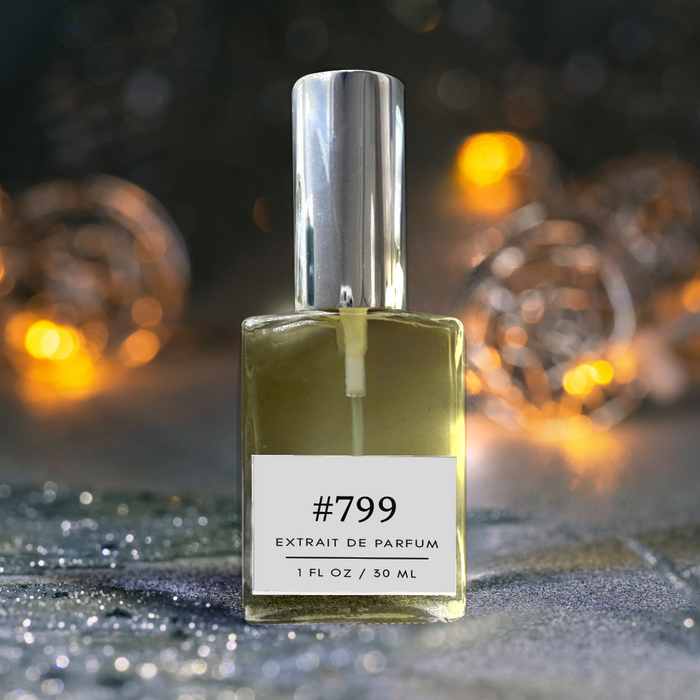 Formula #799 extrait de parfum bottle (1 fl oz/30 ml) standing on a glittery surface with warm golden fairy lights softly blurred in the background.