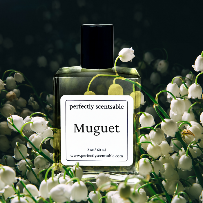 Perfectly Scentsable Muguet perfume oil, 2 oz/60 ml square bottle with black cap nestled among lily-of-the-valley blooms on a dark background.