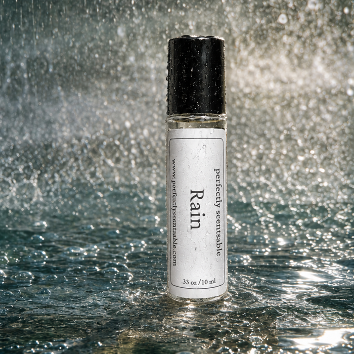 Rain roll-on perfume bottle standing on a wet reflective surface, covered in water droplets with heavy rain and sparkling splashes creating a fresh, aquatic atmosphere.