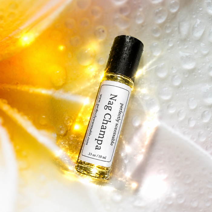 Nag Champa roll-on perfume bottle resting diagonally on a glossy, water-covered surface with golden-yellow light, bright reflections, and scattered droplets creating a luminous, fresh effec