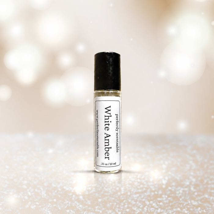 White Amber roll-on perfume bottle centered against a soft ivory background with glowing bokeh lights and a subtly sparkling surface, creating a clean, luminous atmosphere.