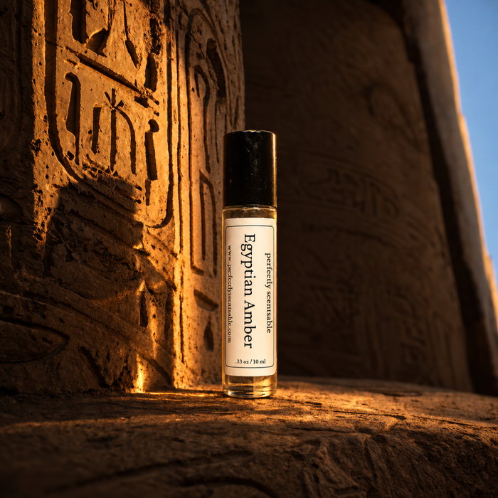 Egyptian Amber roll-on perfume bottle displayed against an ancient Egyptian-style carved stone wall, illuminated by warm golden sunlight with detailed hieroglyphic patterns in the background.