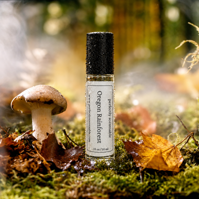 Oregon Rainforest roll-on perfume bottle standing on a rain-soaked forest floor, surrounded by moss, wet leaves, mushrooms, and branches, with water droplets covering the bottle and rain falling in the background.