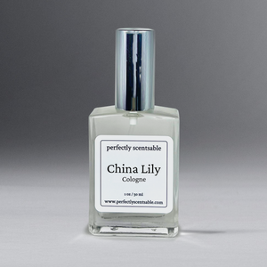 Clear 1 oz cologne bottle with silver cap, gracefully standing against a neutral gray background.