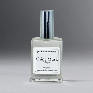 Clear 2 oz cologne bottle with silver cap against a grayish background.