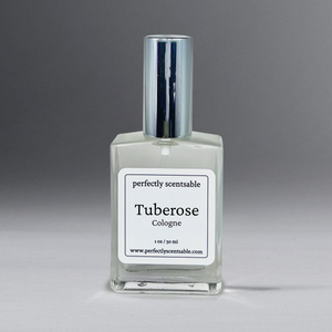 Clear 1 oz cologne bottle with silver cap, gracefully standing against a neutral gray background.