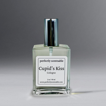 Load image into Gallery viewer, Clear 2 oz cologne bottle with silver cap against a grayish background.
