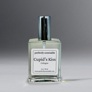 Clear 2 oz cologne bottle with silver cap against a grayish background.
