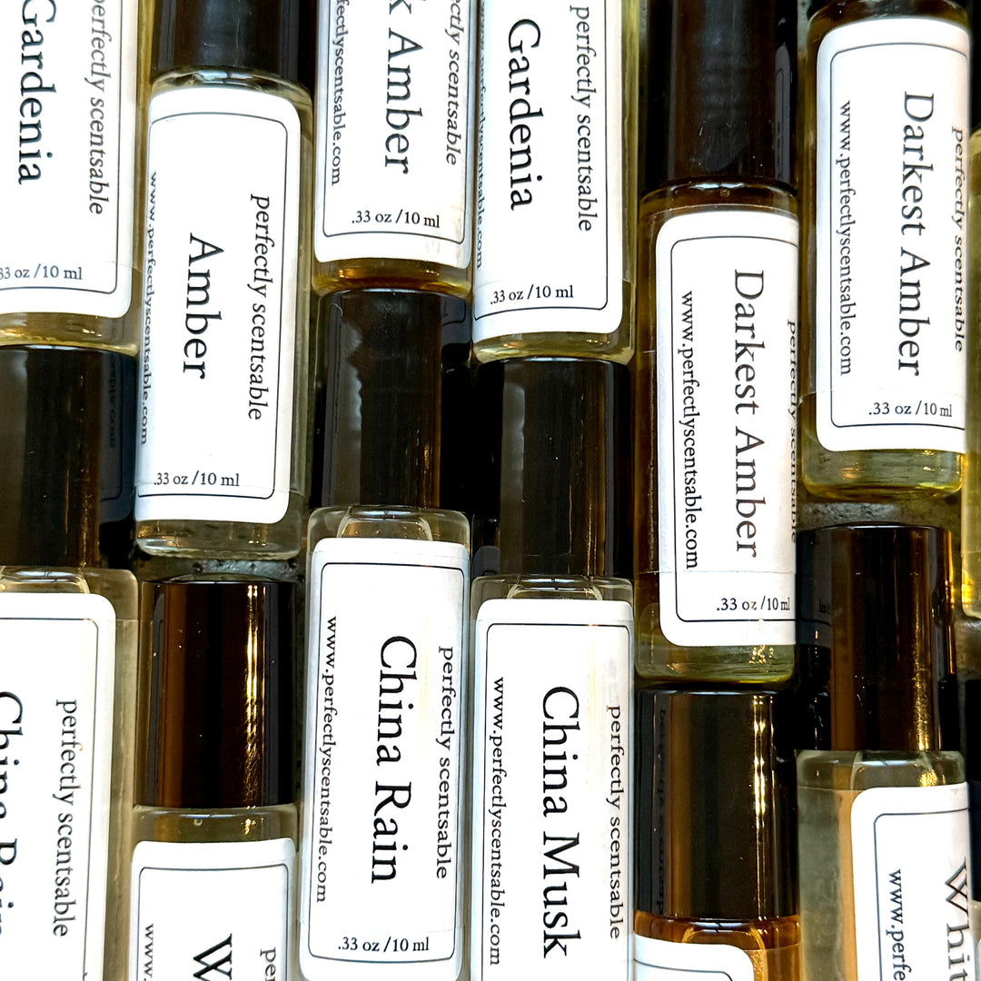 Collection of small perfume bottles with labels on a white background