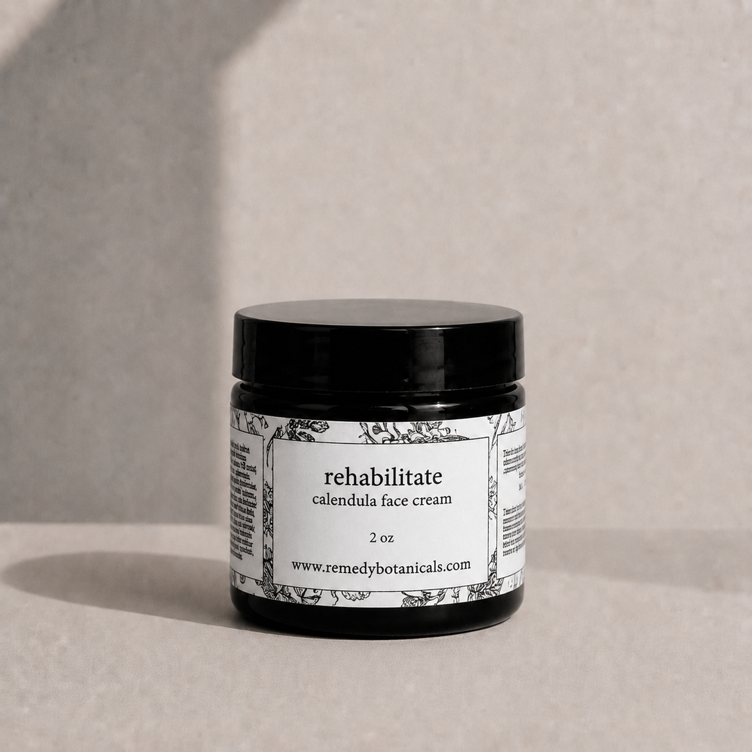 Jar of calendula face cream with a label on a neutral background