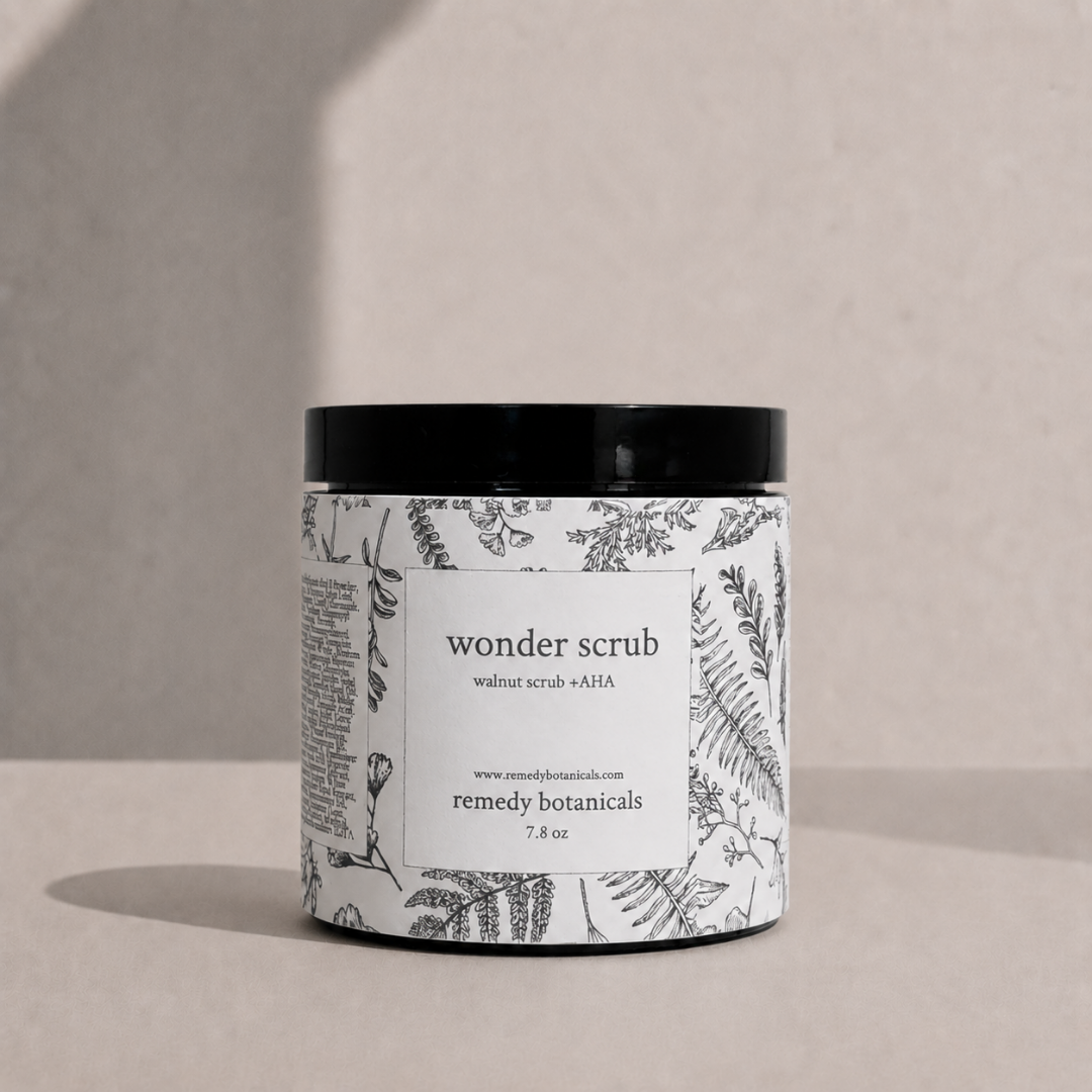 Jar of 'wonder scrub' deep moisturizer with botanical label on a neutral 